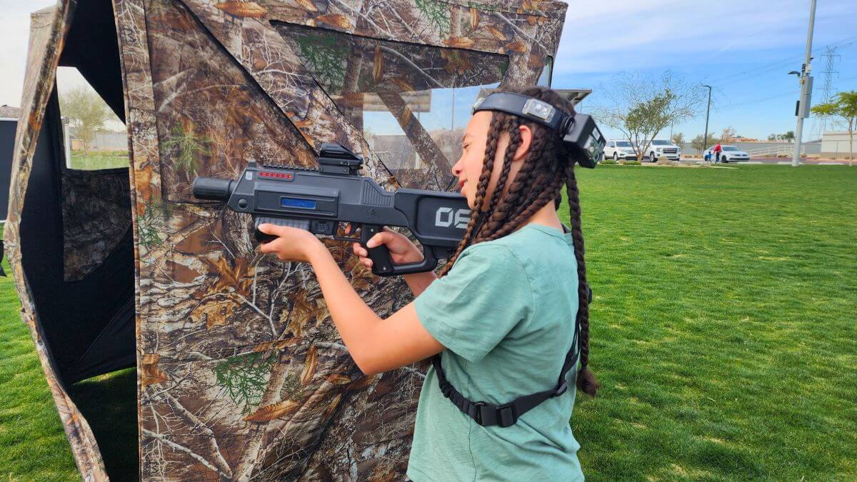 Group playing tactical laser tag outdoors with laser tag guns and bunkers